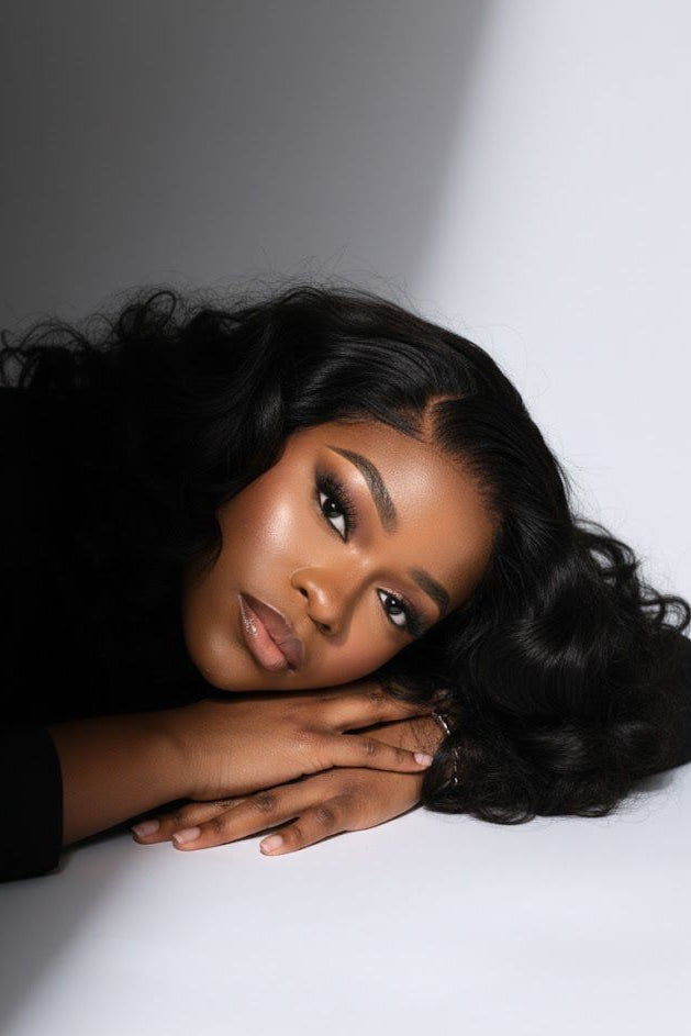 Woman with styled hair resting her head on a white surface